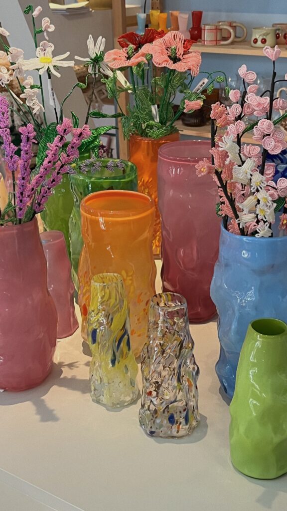 A table of vases and flowers in varying colors.  Spring decor. 