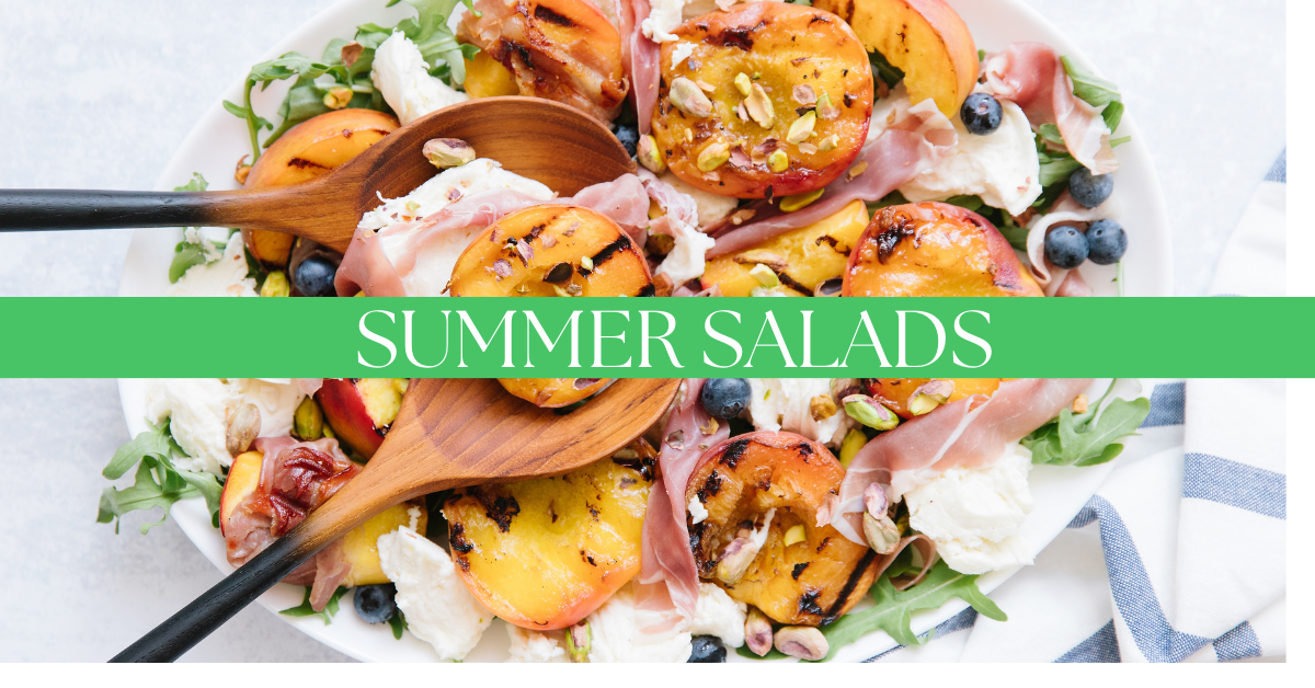 A large bowl of salad with summer fruits such as peaches and blueberries, prosciutto, and mozzarella sit near a blue and white napkin with large wooden salad spoons in the bowl. A green bar splits midway through the photo with a text that reads "summer salads" in white.