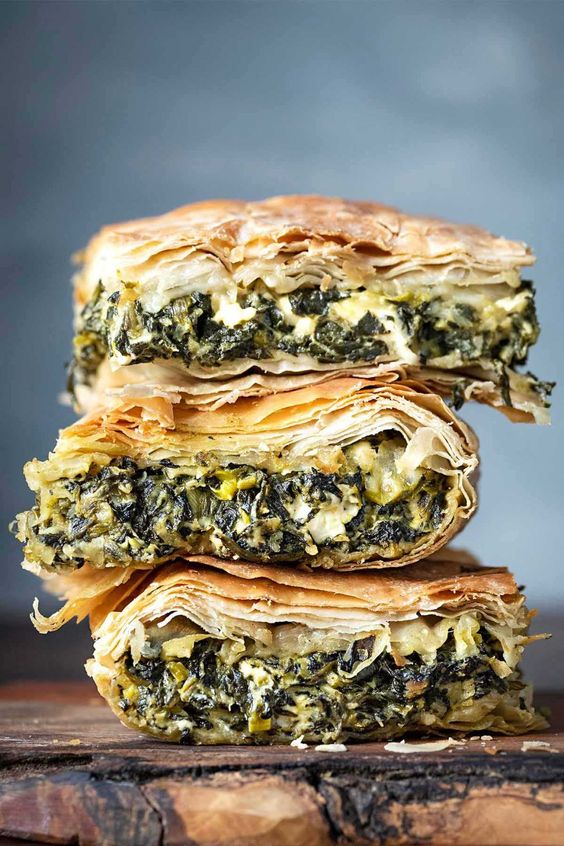 three pieces of spinach pie stacked on top of one another