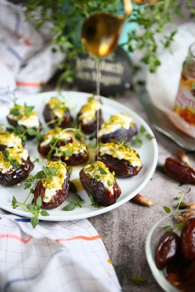 A plate of stuffed dates filled with fresh herbs, crushed pistachios, mascarpone, and honey