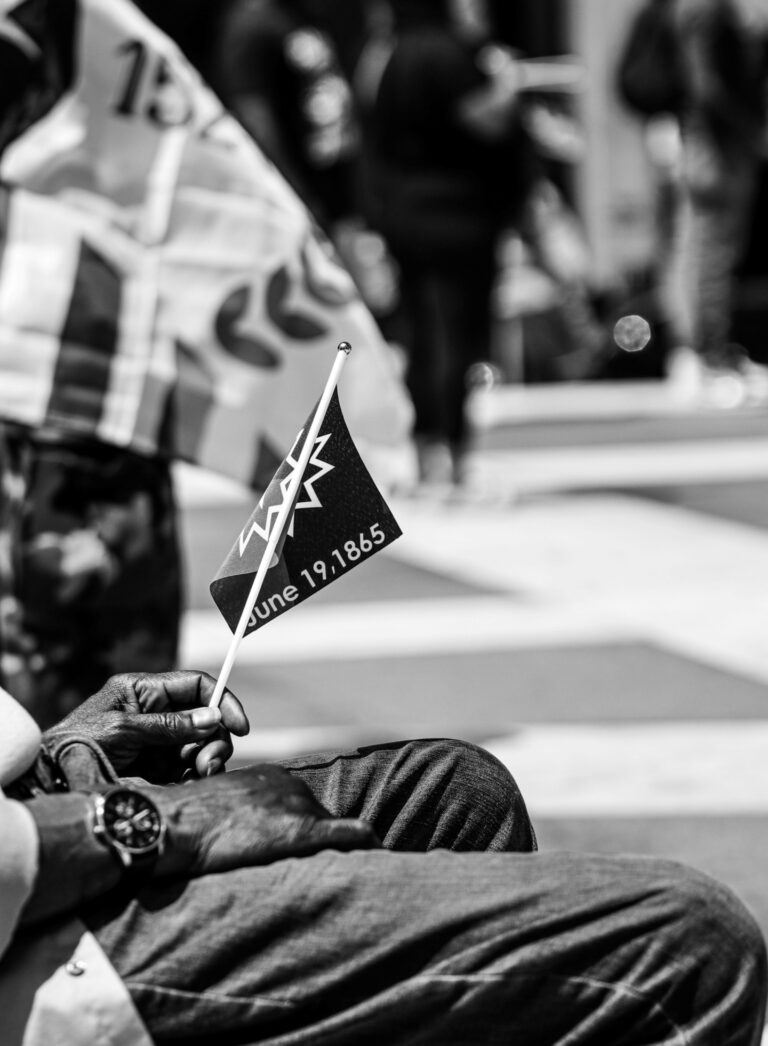 Juneteenth flag in a hand of a sitting person